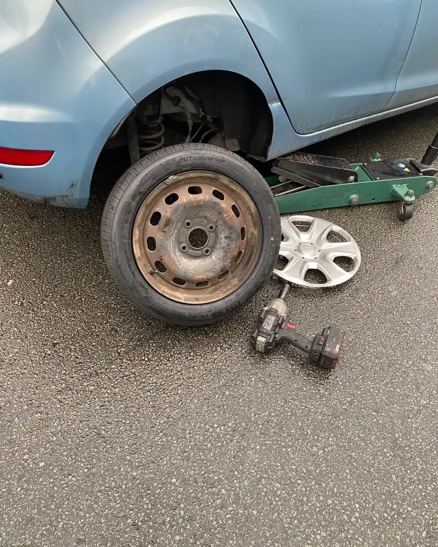 Réparation de pneu crevé sur place à Lille : véhicule sur cric et changement de roue en intervention mobile.